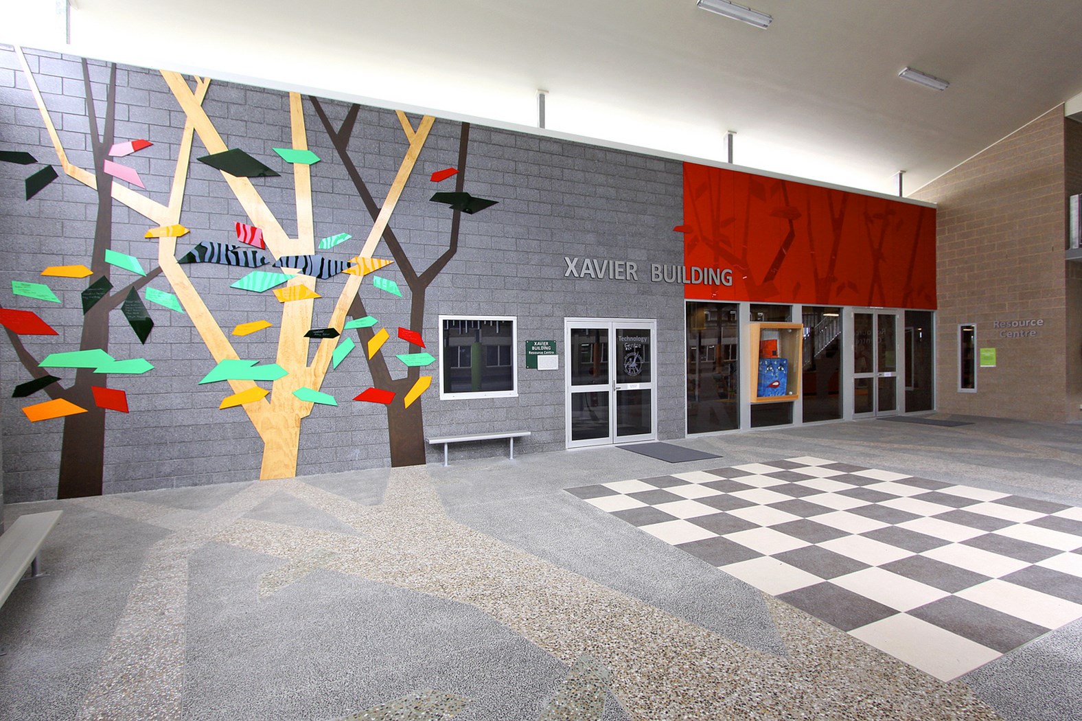 School entrance to the Xavier Building featuring a tree mural with colourful leaves representing learning growth and community within the school environment