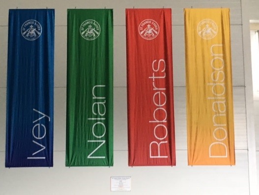 School house banners displaying Ivey Nolan Roberts and Donalison representing student belonging teamwork and school identity