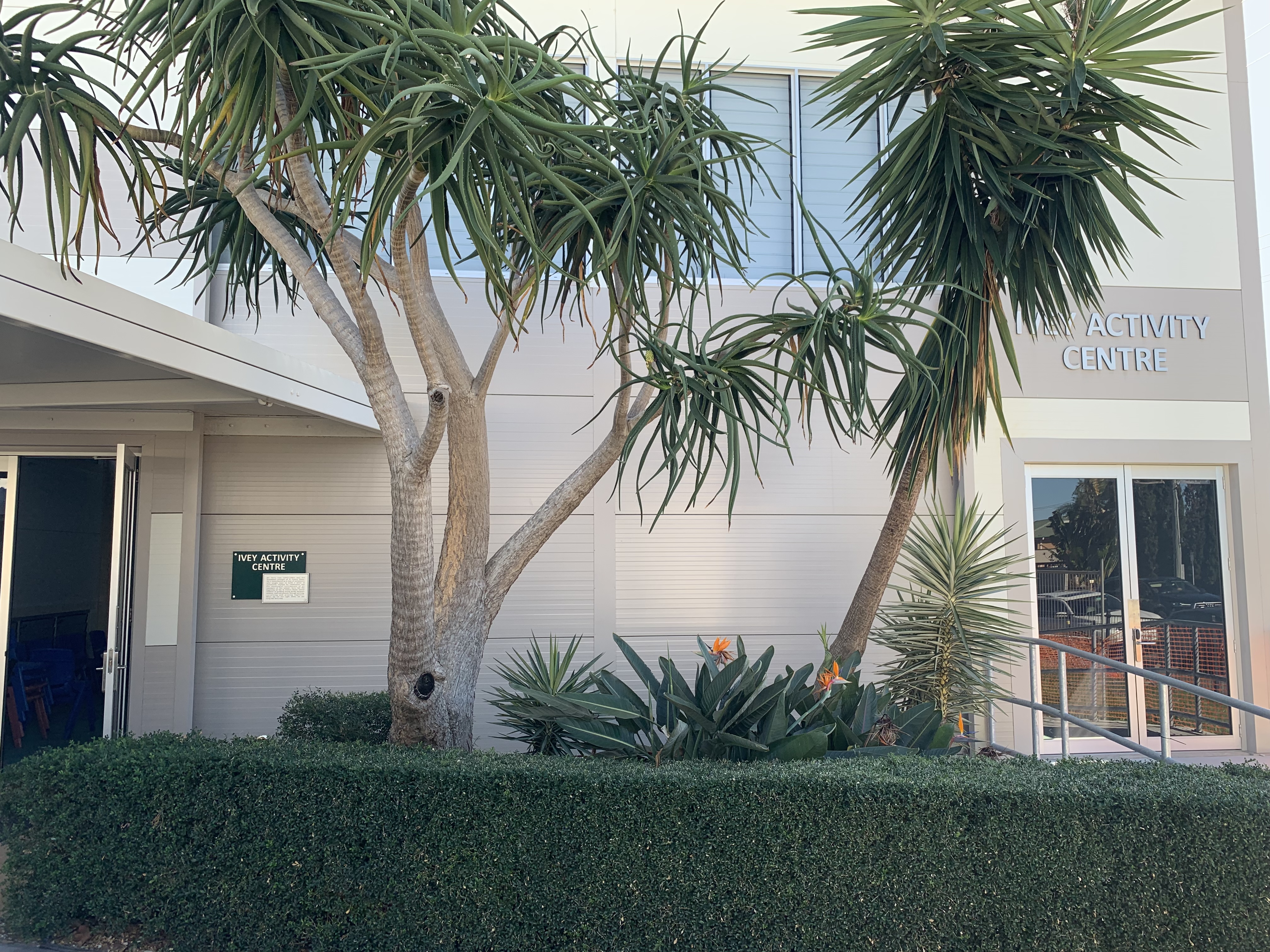 School activity centre entrance surrounded by established trees and landscaped gardens highlighting a welcoming environment and connection to outdoor learning spaces