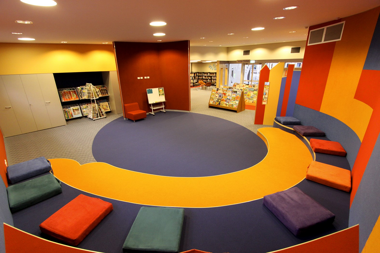 Library reading space with circular seating and colourful furnishings promoting collaboration comfort and student engagement in flexible learning